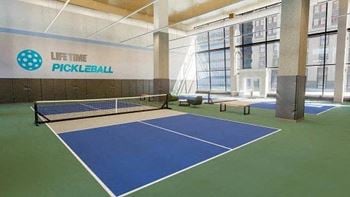 A pickleball court is set up indoors with a net and paddles.